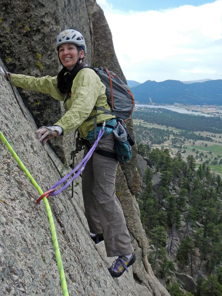 Tori left the belay ledge (at the top of P3) and traversed climber's right to gain the crack for P4. Lake Estes is in the background.