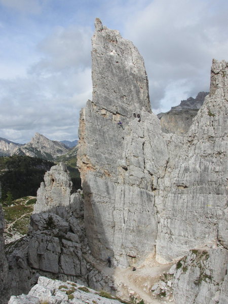 Torre Inglesi and climbers; one stands at the start of the route.