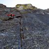 First pitch off the main ledge. The route climbs toward an alcove at the center of the 'hourglass' and then follows the upper-right crack system through numerous exposed roofs on white granite. <br>
<br>
Photo: Corey Gargano