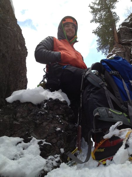 Grover Price sitting on the rock bollard belay. Top of pitch two.