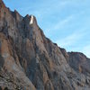 This is Cohete. The route begins in the gully and takes on the spire below the white prominent face. It climbs the right side then after the wide corner pitch the route goes onto the face for the long splitter 6b ending at a big ledge. one more pitch of 5 takes you to the top. All anchors are bolted and you rappel the route. 