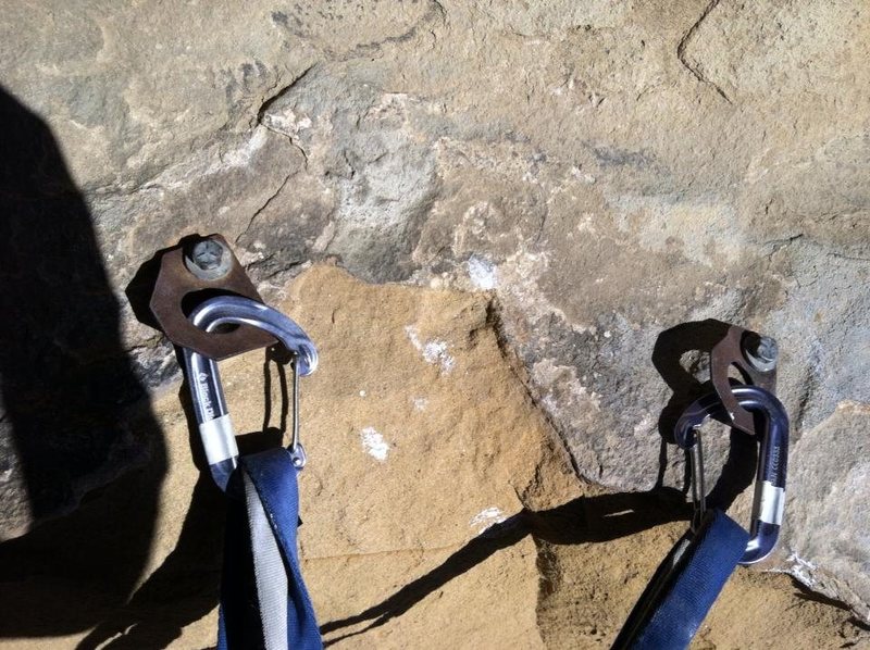 Don't use these bolts that you'll find in the first cave; continue up to to the second cave (~15 feet up) for a better belay station with 2 newer bolts.