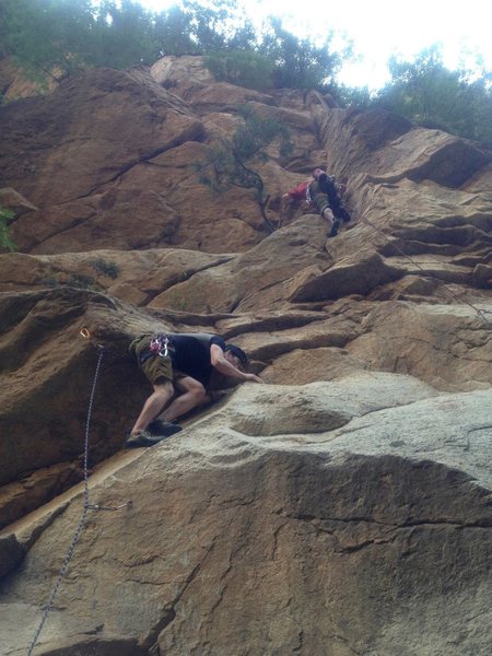 Me at the start of "Three Step" with my friend Ming finishing up the final moves on "Sanbu/The Start."<br>
<br>
"Three Step" moves straight up to the overhang with the right-leaning crack, while "The Start" follows a bolt line down and out of frame to the right of the photo.