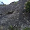 Flake fest begins on a small but easy face and transitions into the incredible finger sized corner crack. Climb towards this and follow the flakes to the top!
