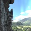 P.Ross near end of traverse P2. The Direct Finish climbs over the roof to his left.