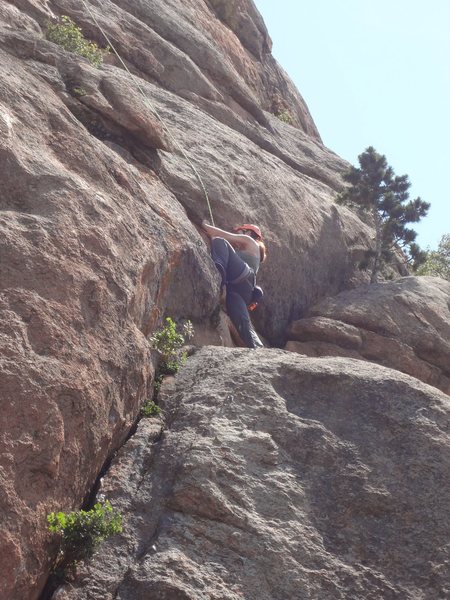 Sasha stepping left before the small ledge and crux.