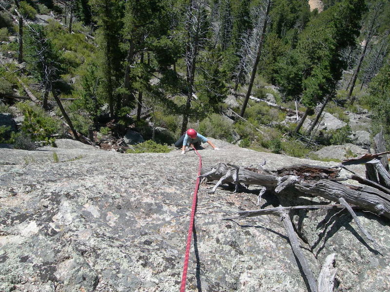 Deb plays on the unprotected slab finish to the climber's left of the crack finish.