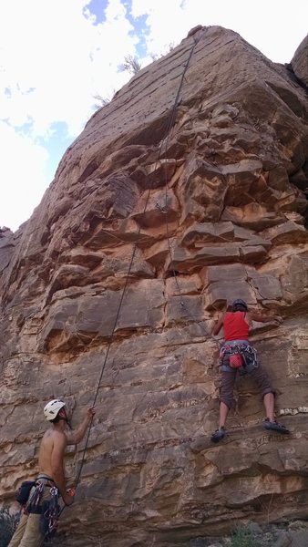 Carrie following Red Hot Rodent ... there is a rock at the base with route name and grade