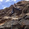 Mark climbing with a broom to clean the route.