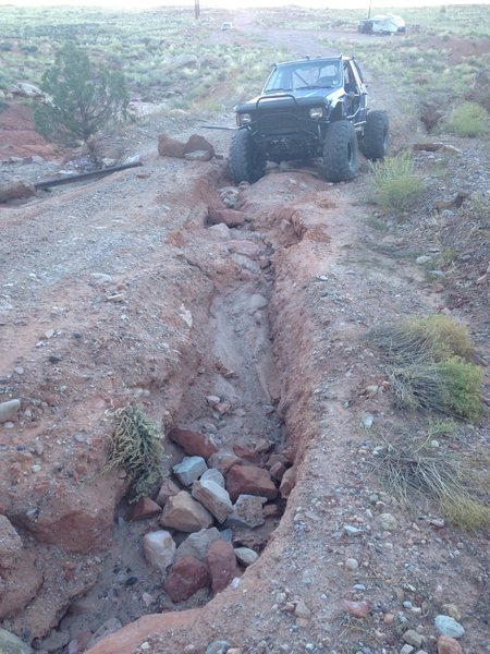 I think the road has washed out a little since a this was written. My little car can be seen behind the stuck truck. From there it was a 15 minute walk up the road to the academy.