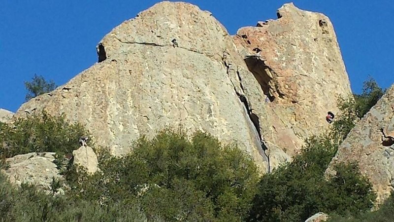 See the climber just above the horizontal crack in the middle of the pagoda rock face on 2nd pitch of dry December . You can also see folks on the pillar (black stain to the right) and in the caves on rock of ages