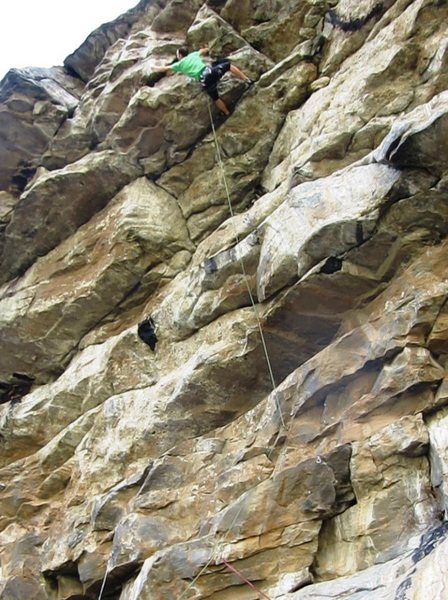 Groping for better holds near the top of the cave.