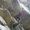 Midway through the crux, making a big reach out to the lip of the largest roof.