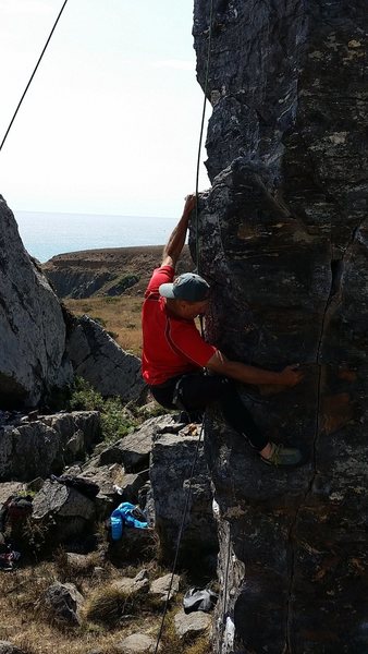 The crux move on Pelican Arete.  A right hand sideways crimp allows the climber to lean left and move up to a great foot hold.  That follows with a stretch upwards to grab the bivy ledge above.