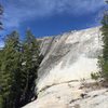 First view of Dark Side Dome when approaching from slabs below. Climbers on 5.8 routes.