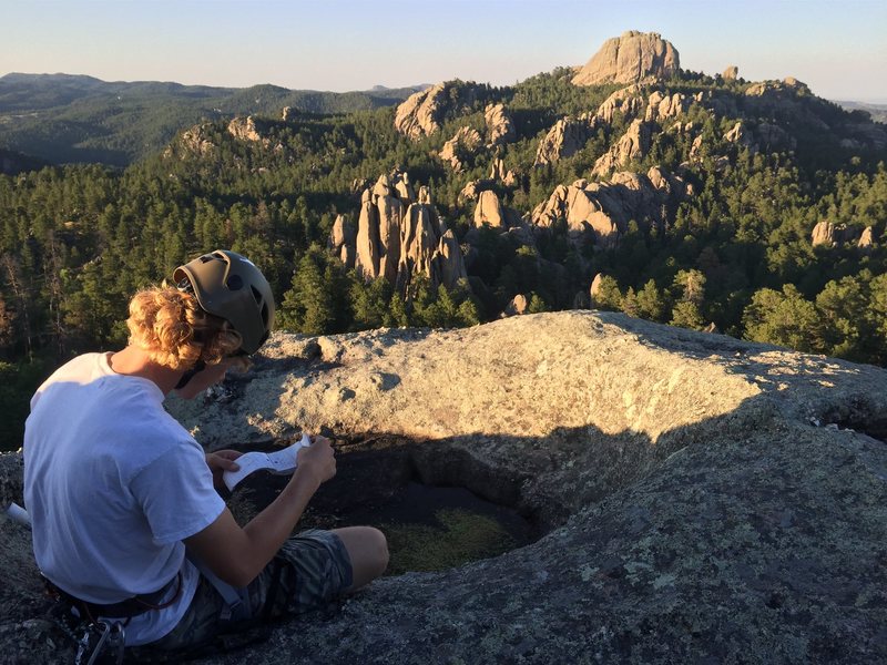 Ben looking through the Pine Tree Rock summit register after coming up the easy solo on the southern side.