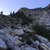 On the right is the headwall. On the left is the steep vegetated dirt. Go all the way to the top of it, then right.