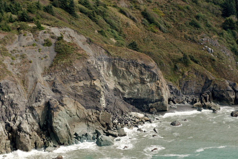 Aerial photo of High Bluffs from the California Coastal Records Project. Copyright © 2013 Kenneth & Gabrielle Adelman <br>
<br>
The climbing routes are on the far right wall, facing south (not the wall facing the ocean). You can see the two trail-marking conifers in the upper center of the photo near the ridge. 