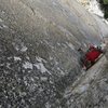 Kyle places a brassy before the crux on pitch 2.