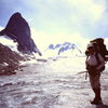 Mary-Jane Cross packing from Kain-Camp (aka "Boulder Camp") to the ACC-GMC Vowell-camp via the Snowpatch- Bugaboo col and the Vowell Glacier (1982).<br>
 Bugaboo on the left, Howser Towers in background. 