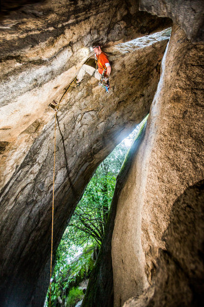 Batman Can't Fly. Photo is at the crux, transitioning from the hand crack to the roof. I find it easiest to traverse to the far end of the chimney, where it is wider, then squeeze through there. 