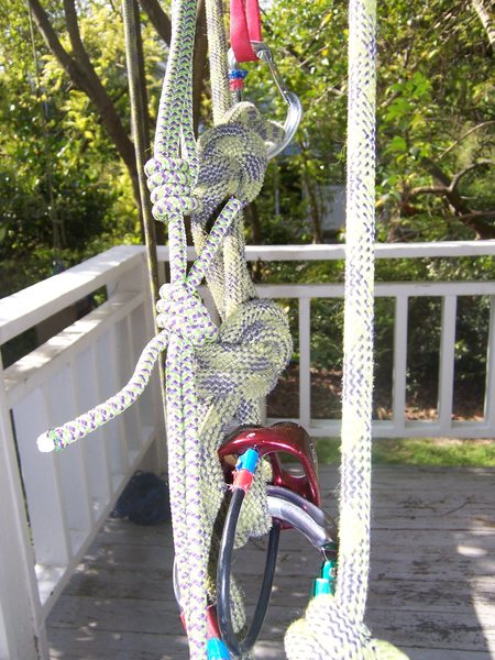 Step 2: Tied off munter-mule with overhand back-up. the red sling and wire gate are clipping the loop of the munter-mule to the masterpoint.