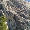 Extremely foreshortened view of the route from the base.  Starts just out of view to the right at the base of a large boulder.  Move up and left to the small conifer on the face, then continue left to the obvious dike/chimney/corner system.