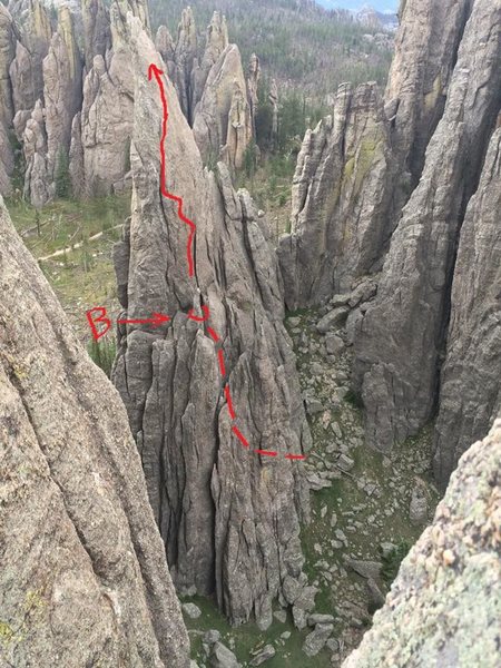 After climbing this formation a couple times via different lines, I think this is the 5.8 line most would consider the easiest way up Eyetooth.  After the first gulley pitch (dotted line - gulley not able to be seen from this angle) belay from the ledge, and go right up the large flake, making your way up and left via the flakes to the final bolted slab.  