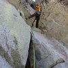 John entering the flaring chimney on Pitch 7. In his Cascades Rock guidebook, Blake called this the "region's hardest '5.8'". 