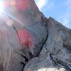 From a belay on the shoulder, ascend a trough on the ridge's west side to a pair of cracks that lead up the shoulder of the ridge again.