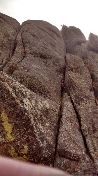 Ross is on the ledge at the base of the summit block on the easternmost blunt summit tower.  He is adjusting the rope and the directional at the top of the short, difficult, vertical wall on the left of the easternmost tower.