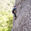 Past the crux, Ian makes a high step towards easier ground on Orangahang at San Ysidro.