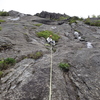 The usual first belay point  ... room to sit to belay, and enough room for others to sit and join you, only about 140 ft up. The big central projection in the distance is ... Bob's Knob