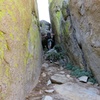 There is a chockstone blocking the head of the gully. It requires a burly move to surmount. Or if descending, there is a rap station on it.