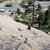 This photo shows the first pitch.  There are several routes up this slab.  The granite is well jointed (cracked), so there is protection running in a grid pattern. Maria is climbing in this photo.