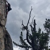 Sage with a high foot on the upper crux.