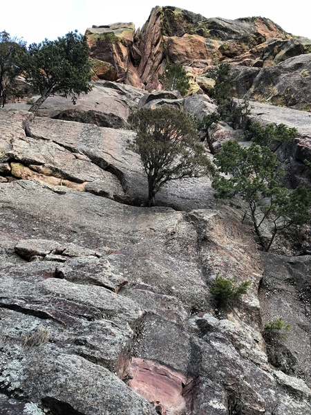 The obvious slot is your destination, climbing first the right hand side then the left.
<br>

<br>
The bush in pic center hides a nice dihedral on P1. The second rap was off  the tree (white bark) near yellow and orange lichen. The belay for P2 was near the top of this tree on the right.