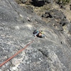 Alex climbing up the first 5.10b crux on pitch 5