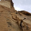 Looking up from the start of P1. Climber can be seen looking up from near P1 anchors