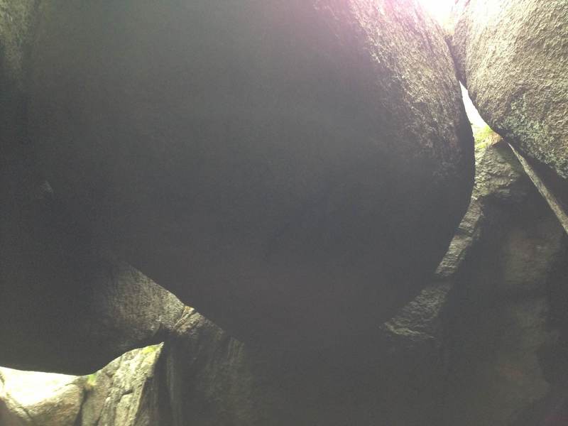 Looking up from the gully below at the large wedged boulders. The easiest way to the more westerly crags is to descend into this gully here.