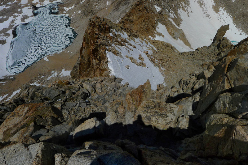 Looking down the descent from just below the top. Careful downclimb to steep snow, then down reasonable scree to snow field below.