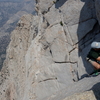 Matt on the lower section of the crux (lieback with the 2 pitons)