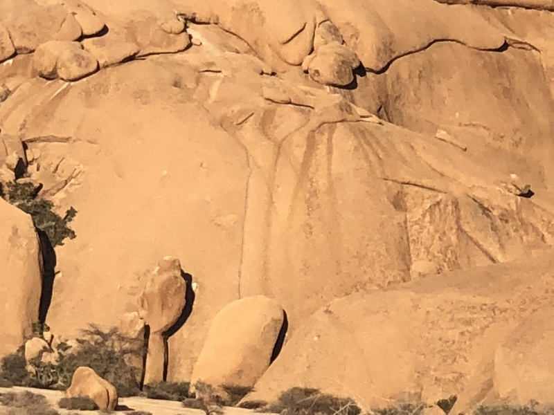 The grayish colored granite water groove emerging directly above the inverted u-shaped boulder like flake that hides the first pitch.