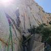 Belay at top of P6. Lindsay climbing the dihedral on P7. Should have moved the belay...