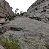 The start of P1 on a distinct slab to the left of Cajun Capers. The ropes in this photo are off route up a vegetated crack at the far left of the slab. The official start is on the slab which is bit runout with groundfall potential in the first ~20'.