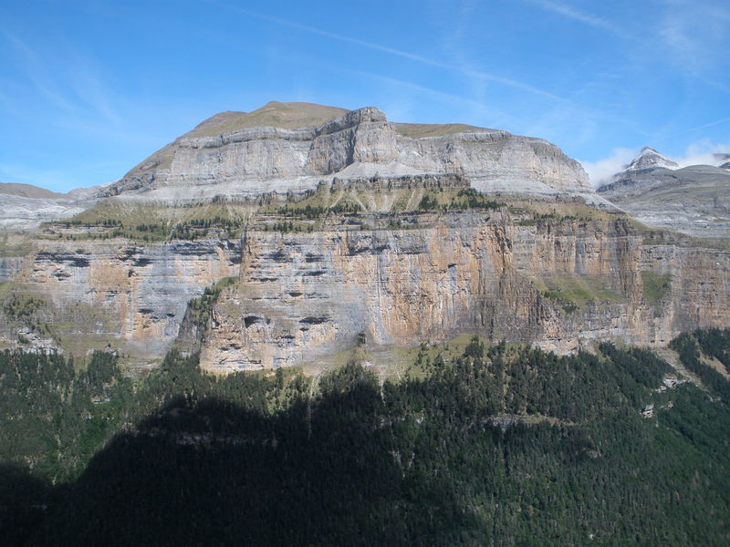 You're looking at about 1/4 of the East side of Ordesa Valley.  The lower cliff is about 8-10 pitches high, then some trees and talus, then the upper cliff is about 4-5 pitches high.