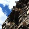 15 feet to the left (when facing out from cliff) of where the main trail terminates at the cliff. Rappelling down to climb up.