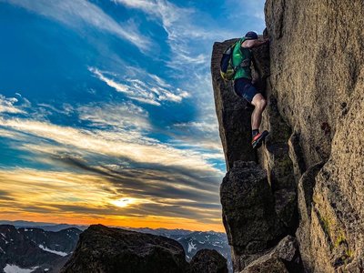 Erik Sanders navigates the crux "Rocker-Blocker" downclimb on the Keyhole Ridge at sunset.