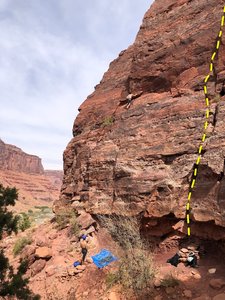 Climber on Encore. Babel start at the rock pile to the right where the bags are.