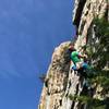 Michael works his way up the flake towards easier terrain